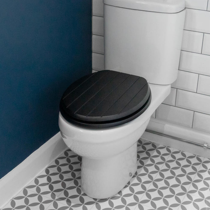 Black soft-close tongue and groove MDF wood toilet seat showing seat in place on a white ceramic toilet