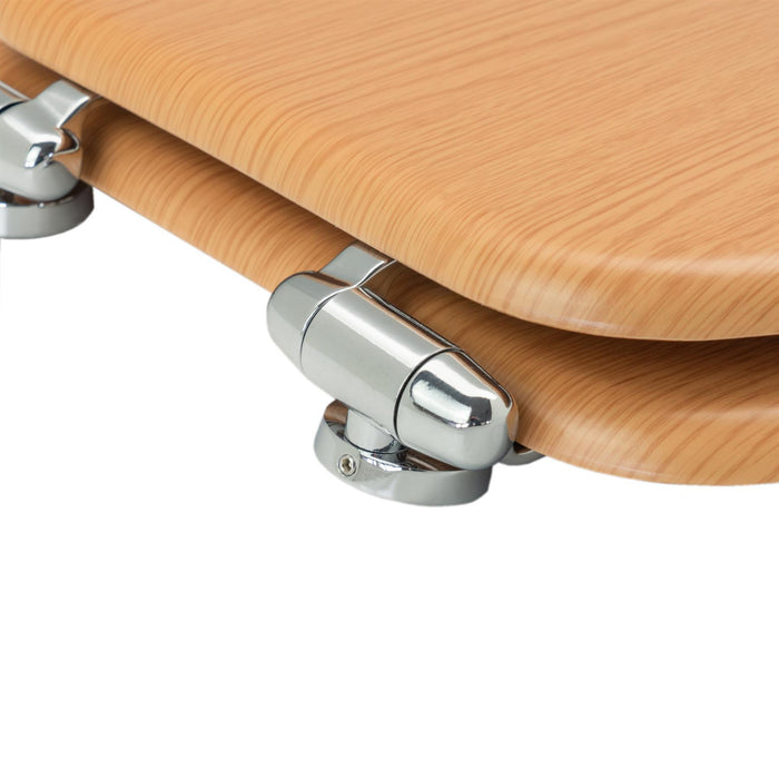 Close-up of chrome-plated soft-close hinges on a brown soft-close tongue and groove MDF wood toilet seat