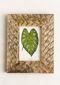 A mango wood picture frame with textural carved leaf pattern.