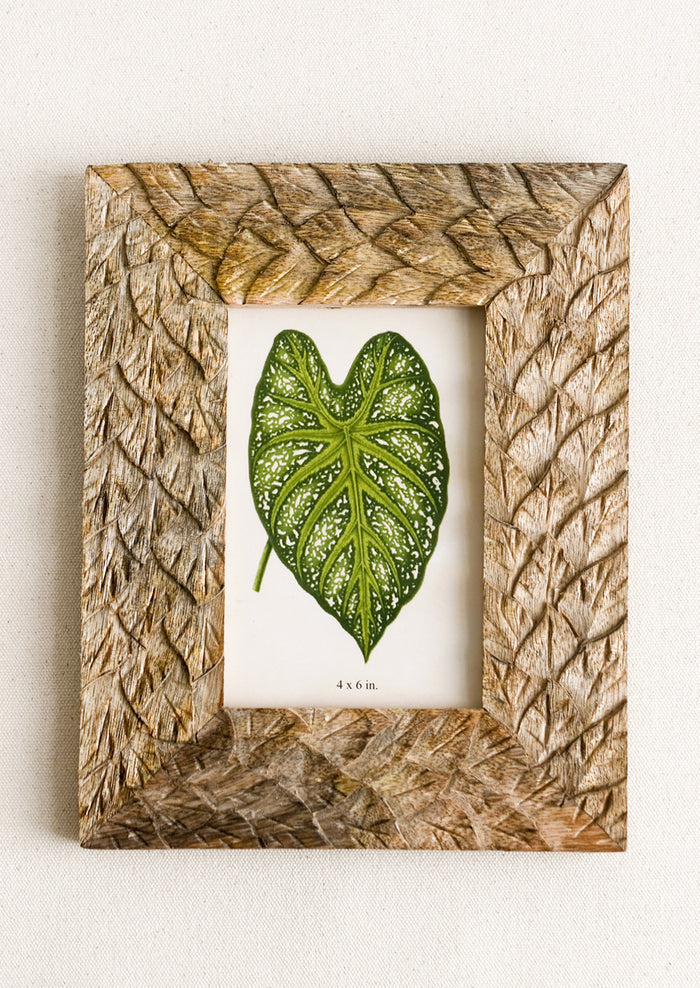 A mango wood picture frame with textural carved leaf pattern.
