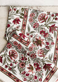 A block printed, floral patterned tablecloth in shades of pink and sage green.