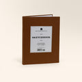Large sketchbook with a chestnut brown cover standing upright with a white Sketchbook label