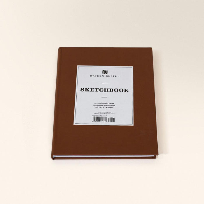 Large sketchbook with a chestnut brown cover lying flat with a white Sketchbook label