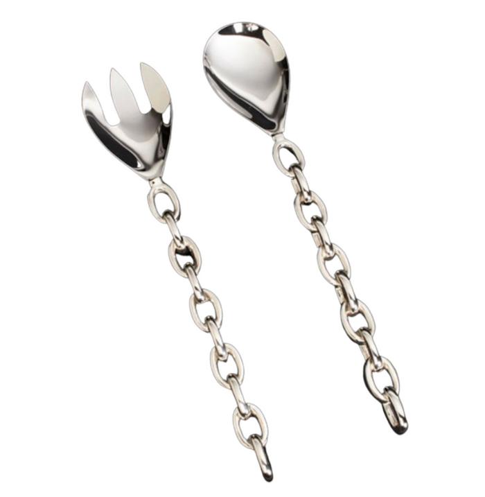 The Linky Salad Set by Inspired Generations features two handcrafted polished aluminum servers—one pronged, one rounded—with chain-link handles. Displayed on a white background, this set adds an elegant touch to your table.