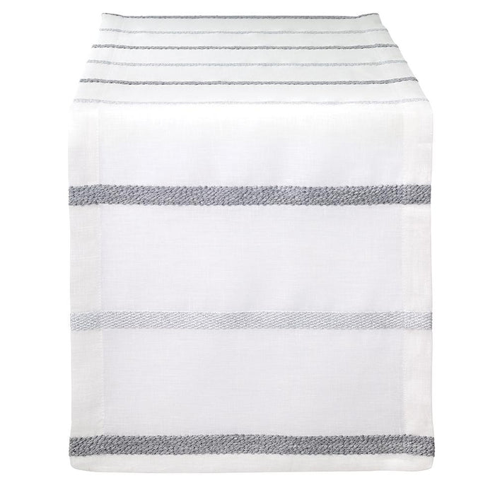 The Bodrum Metallic Band Silver Table Runner features a sleek, minimalist design with metallic silver bands, elegantly draped over the edge of a table.