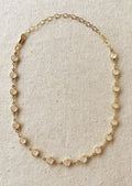 A gold necklace with round opal stations throughout.