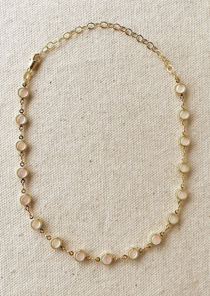 A gold necklace with round opal stations throughout.