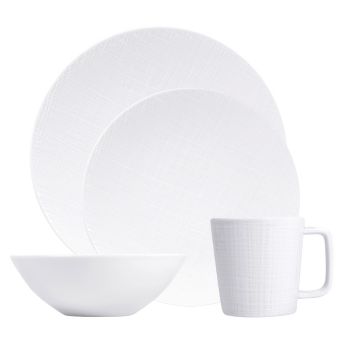 The Bernardaud Organza White Dinnerware set features a large plate, small plate, bowl, and mug with a subtle textured pattern—ideal for minimalist décor.