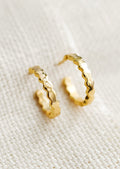 A pair of small gold hoop earrings with wavy shape.
